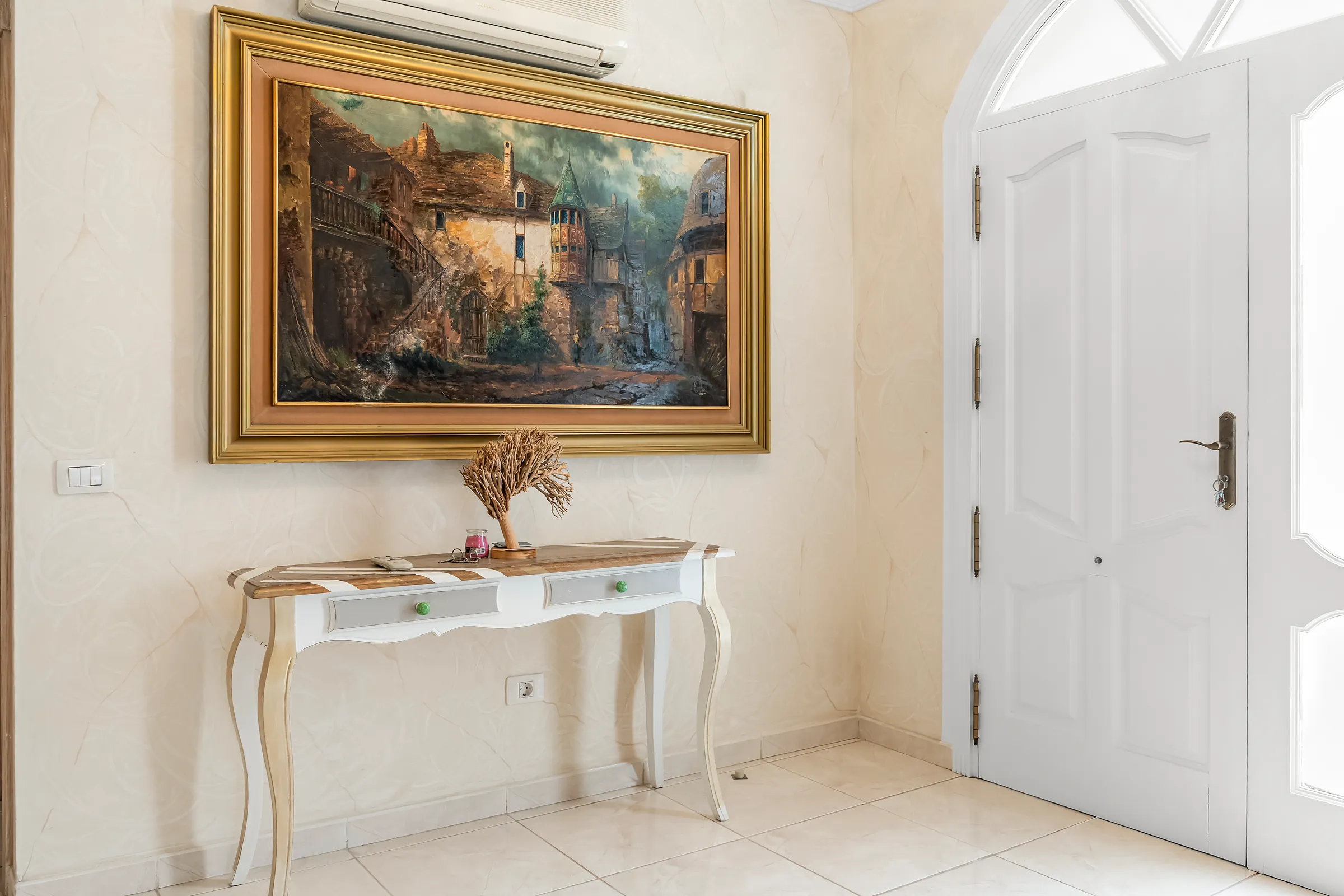 Eingangsbereich der Villa Alexander mit Konsolentisch, Wandbild und Haustür