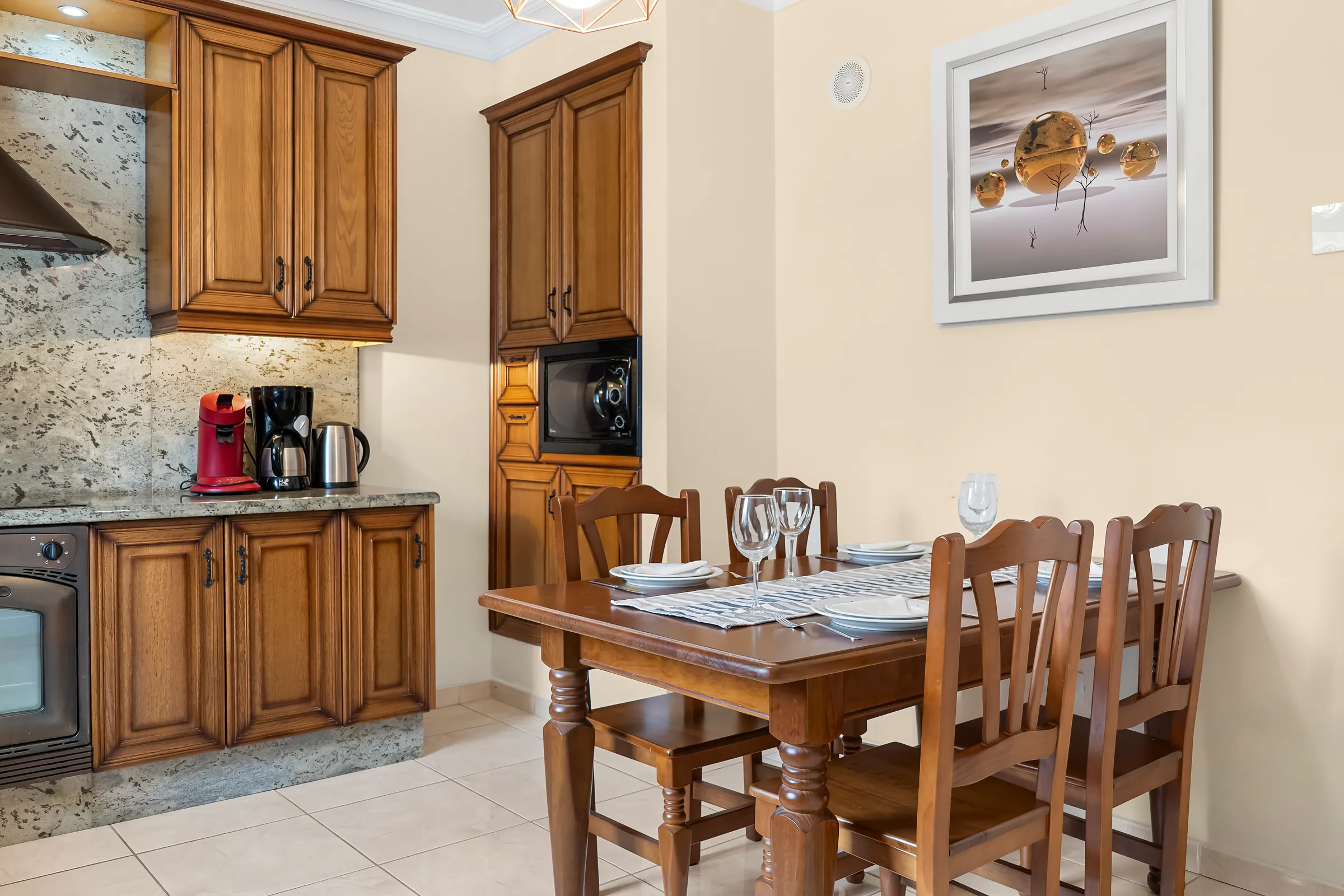 Essbereich in der Küche der Villa Alexander mit Holztisch und Backofen