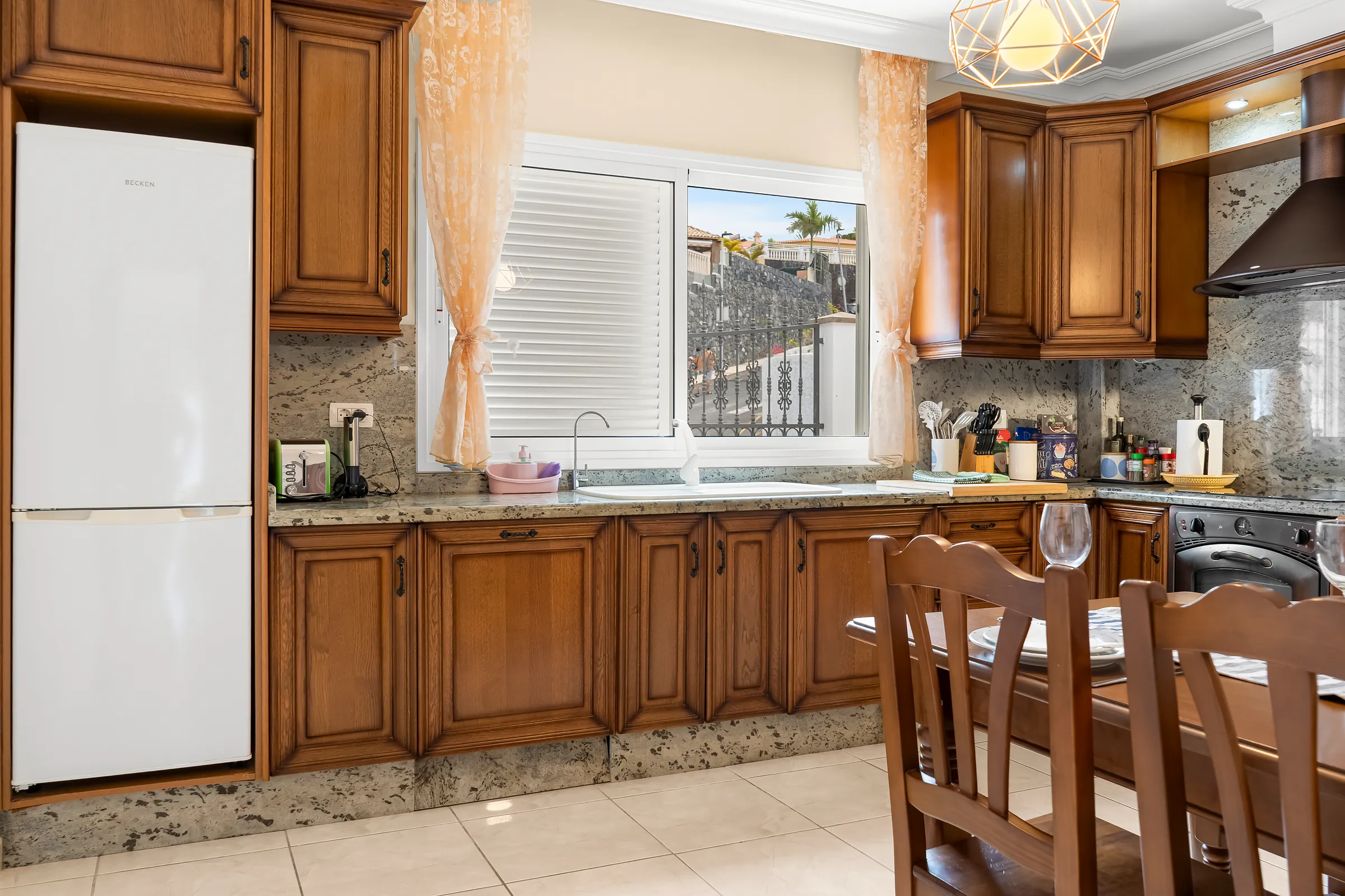 Küche der Villa Alexander mit Holzfronten, Kühlschrank und Esstisch