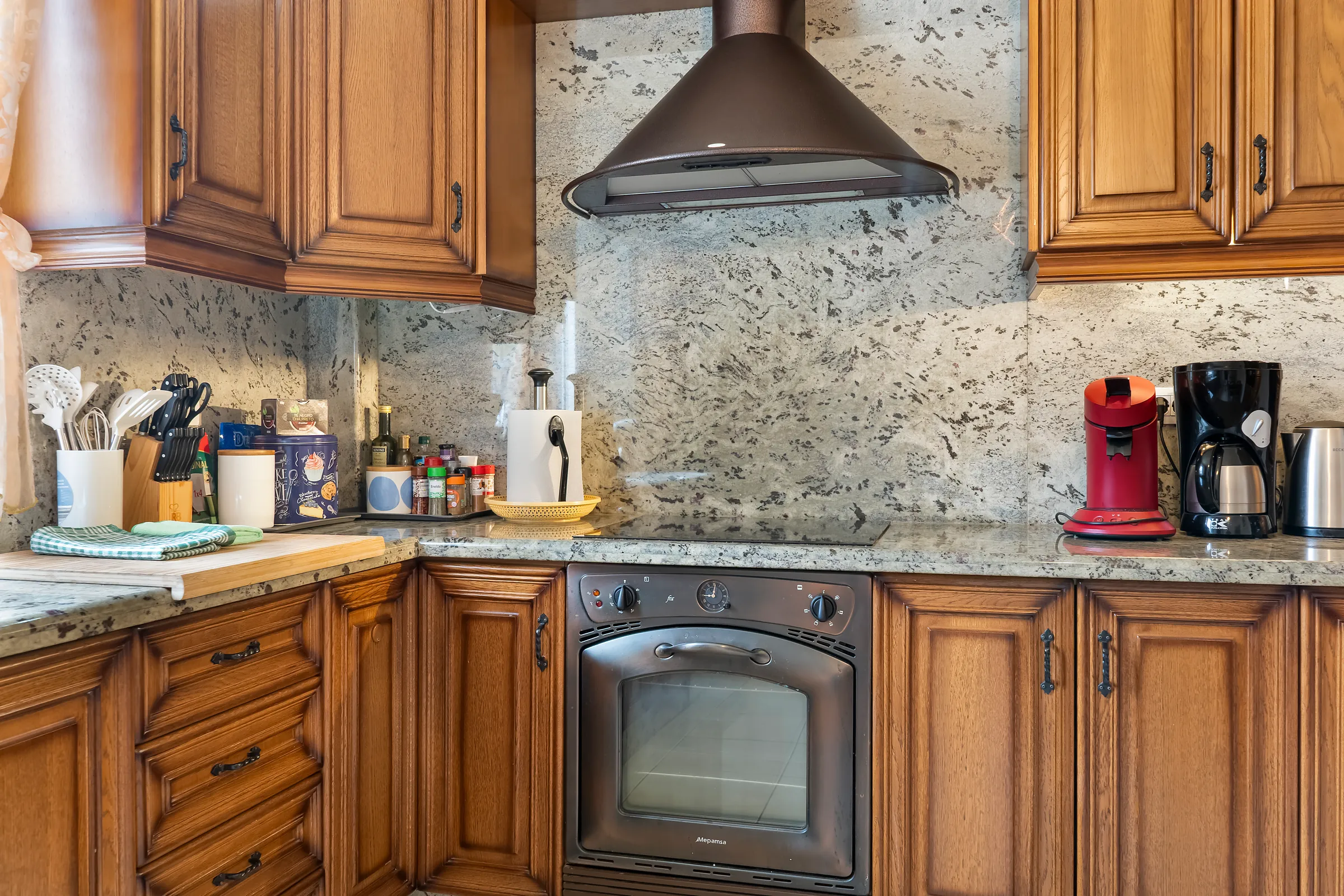 Küchenzeile der Villa Alexander mit Backofen, Dunstabzug und Kaffeemaschine