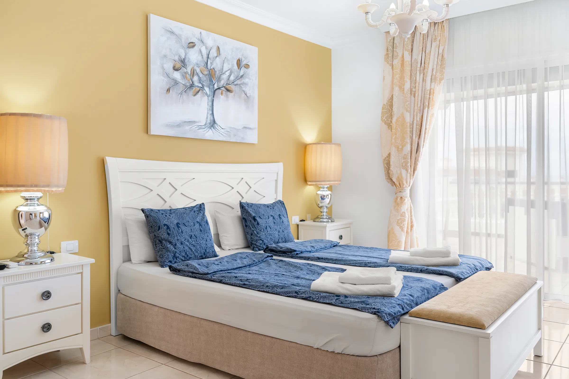 Doppelbett mit Nachttischlampen in Schlafzimmer 1 der Villa Alexander