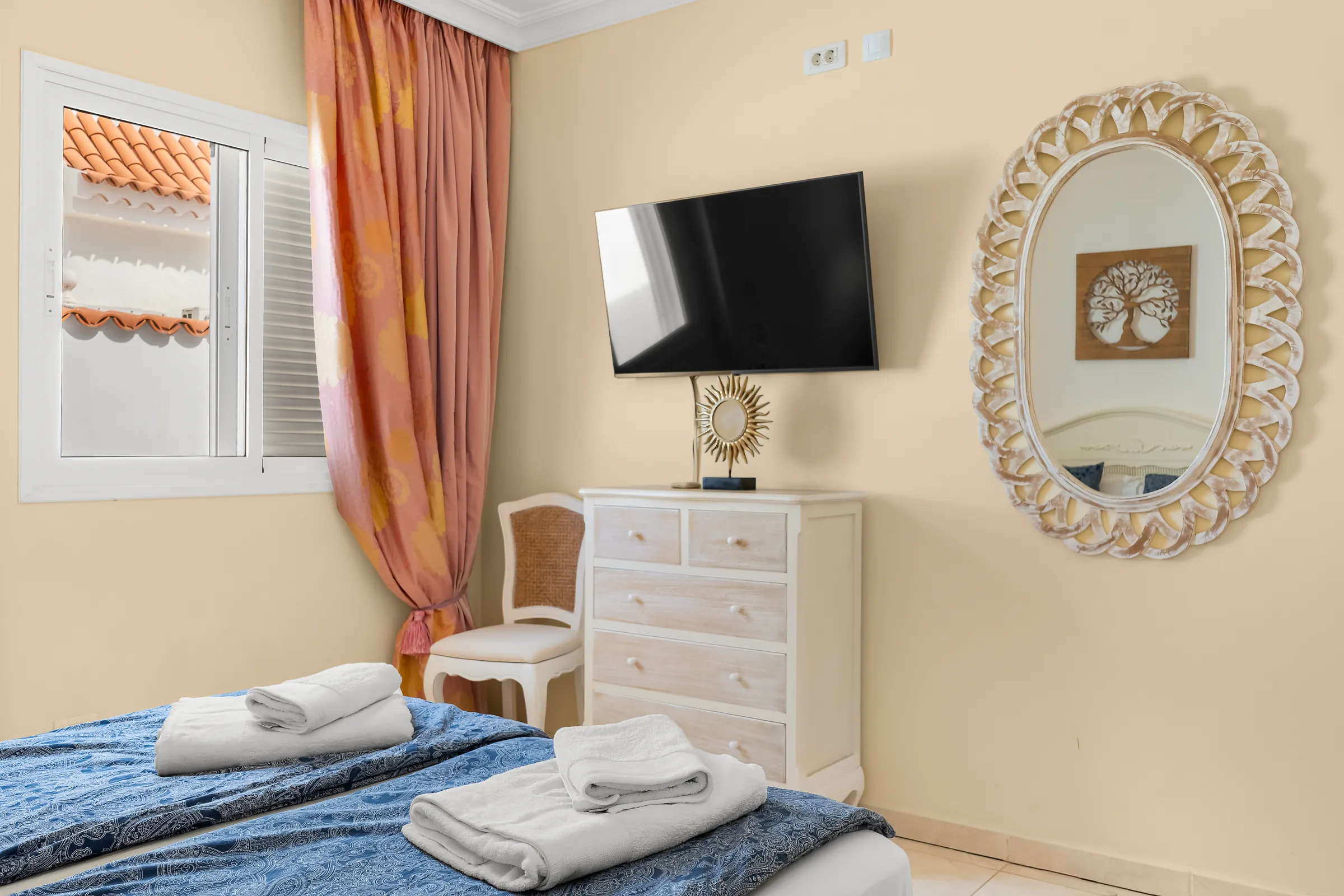 Schlafzimmer 2 der Villa Alexander mit Fernseher, Kommode und Spiegel