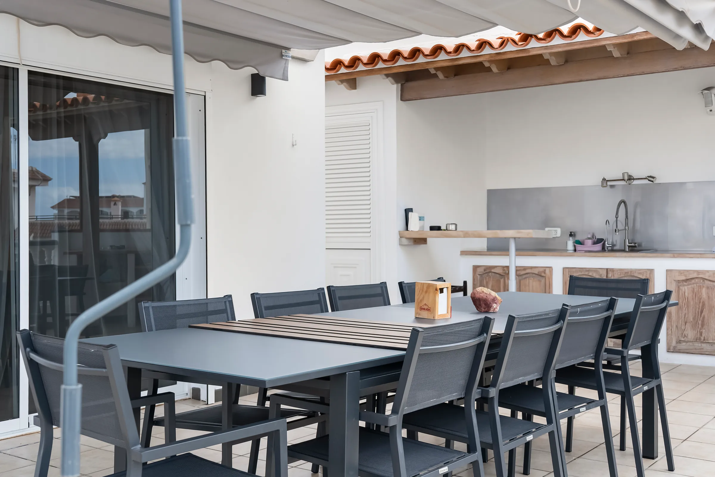 Esstisch für mehrere Personen vor der Sommerküche auf der Terrasse der Villa Alexander