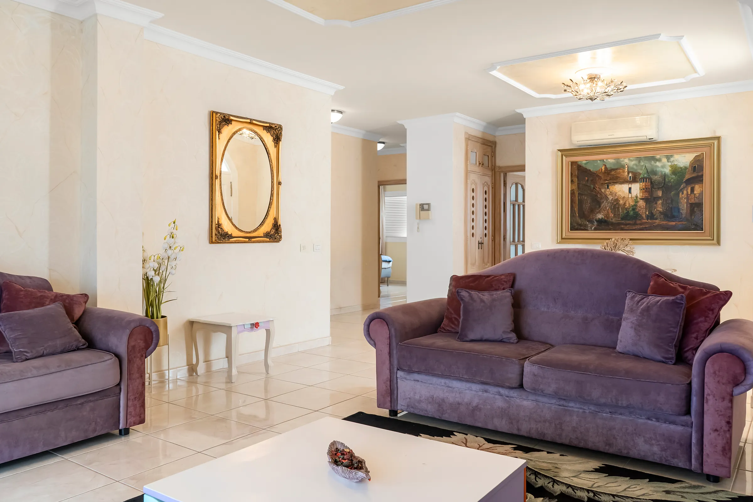 Wohnzimmer der Villa Alexander mit Sofas, Wandbild und Spiegel
