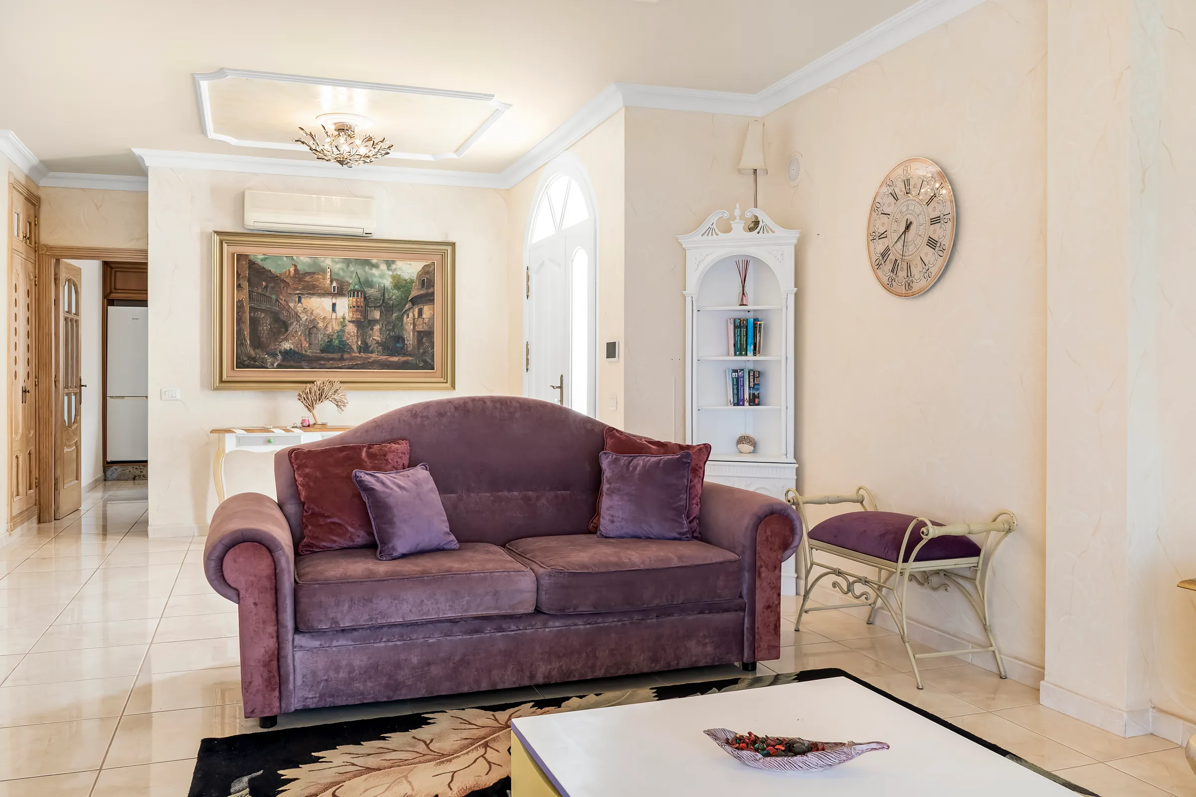 Samtsofa im Wohnzimmer der Villa Alexander mit Wandbild und Eckregal