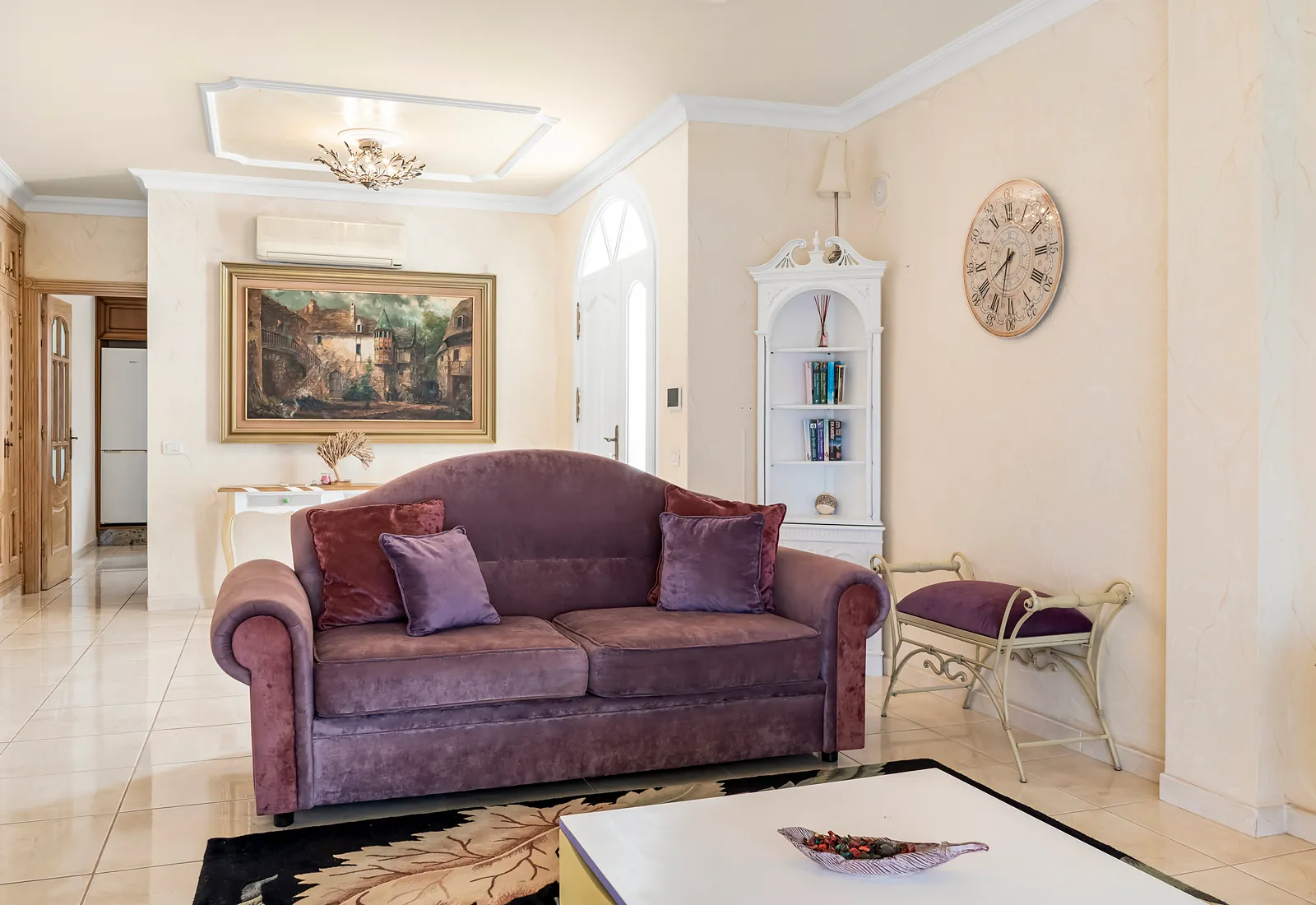 Samtsofa im Wohnzimmer der Villa Alexander mit Wandbild und Eckregal