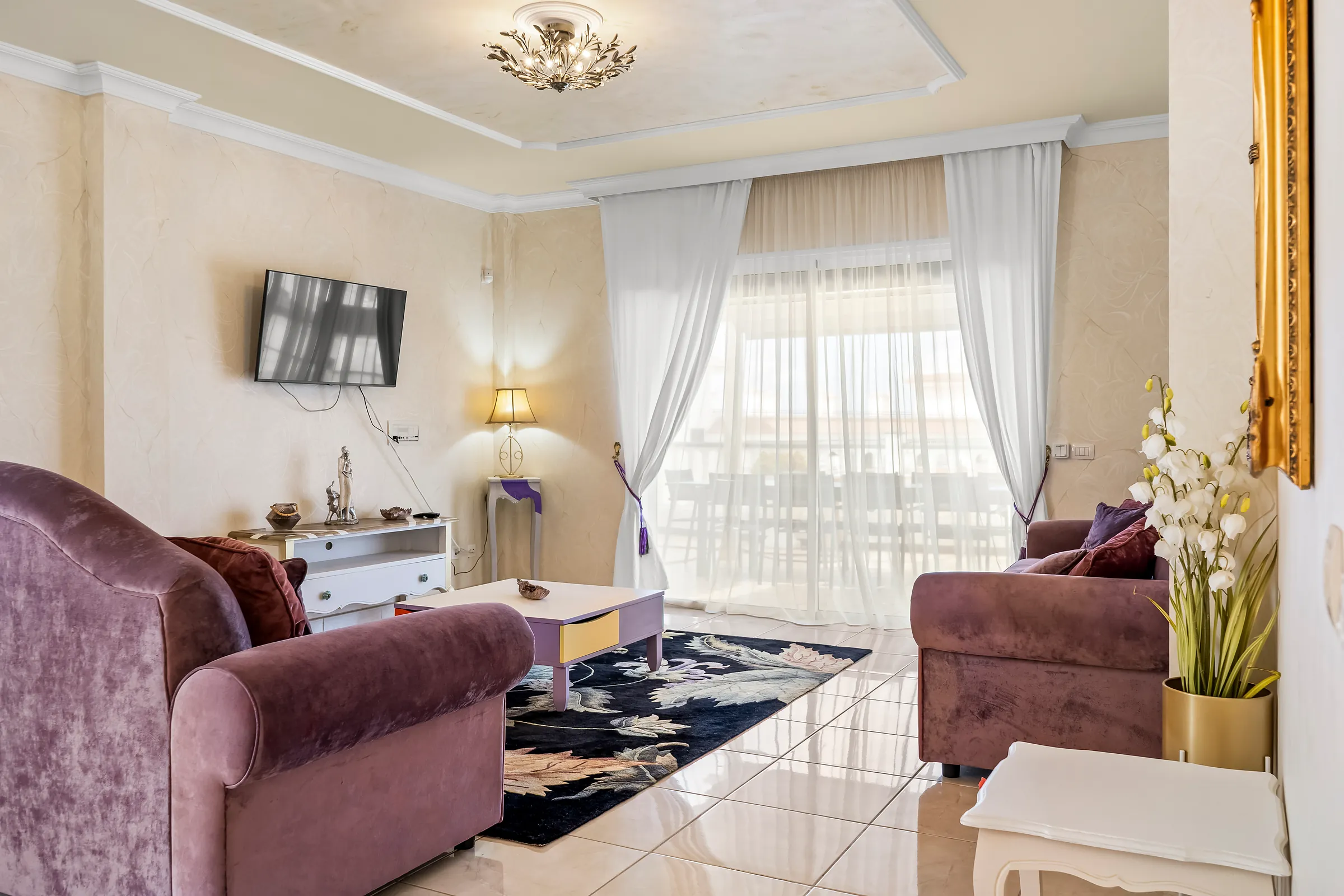 Wohnzimmer der Villa Alexander mit Sofas und Schiebetür zur Terrasse