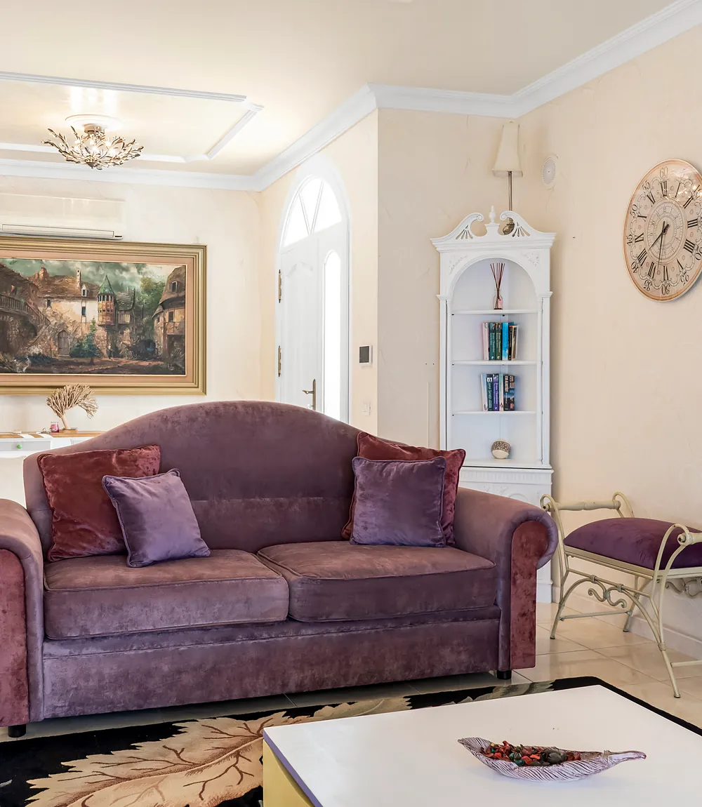 Samtsofa im Wohnzimmer der Villa Alexander mit Wandbild und Eckregal